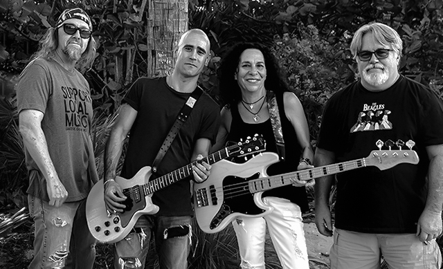 Black & White photo of 4 members of Cover To Cover Band, centermost two musicians holding guitars