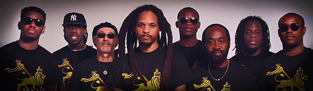 Portrait of 8-Member Band Army Gideon, all wearing black shirts with yellow lion band logo