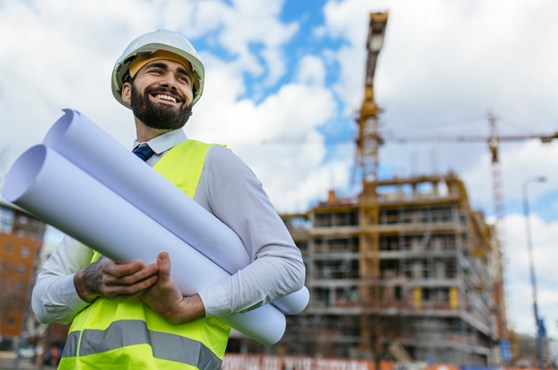 planner outside holding plans under his arm