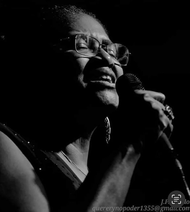 Black and white closeup of Yvette Norwood-Tiger singing into a microphone