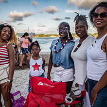 Image of happy family in patriotic attire with Intercoastal Waterway and blue sky behind them on July 4.