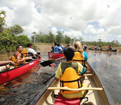 students paddling canoes