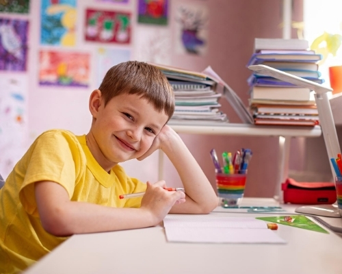 Child at desk at home with art supplies