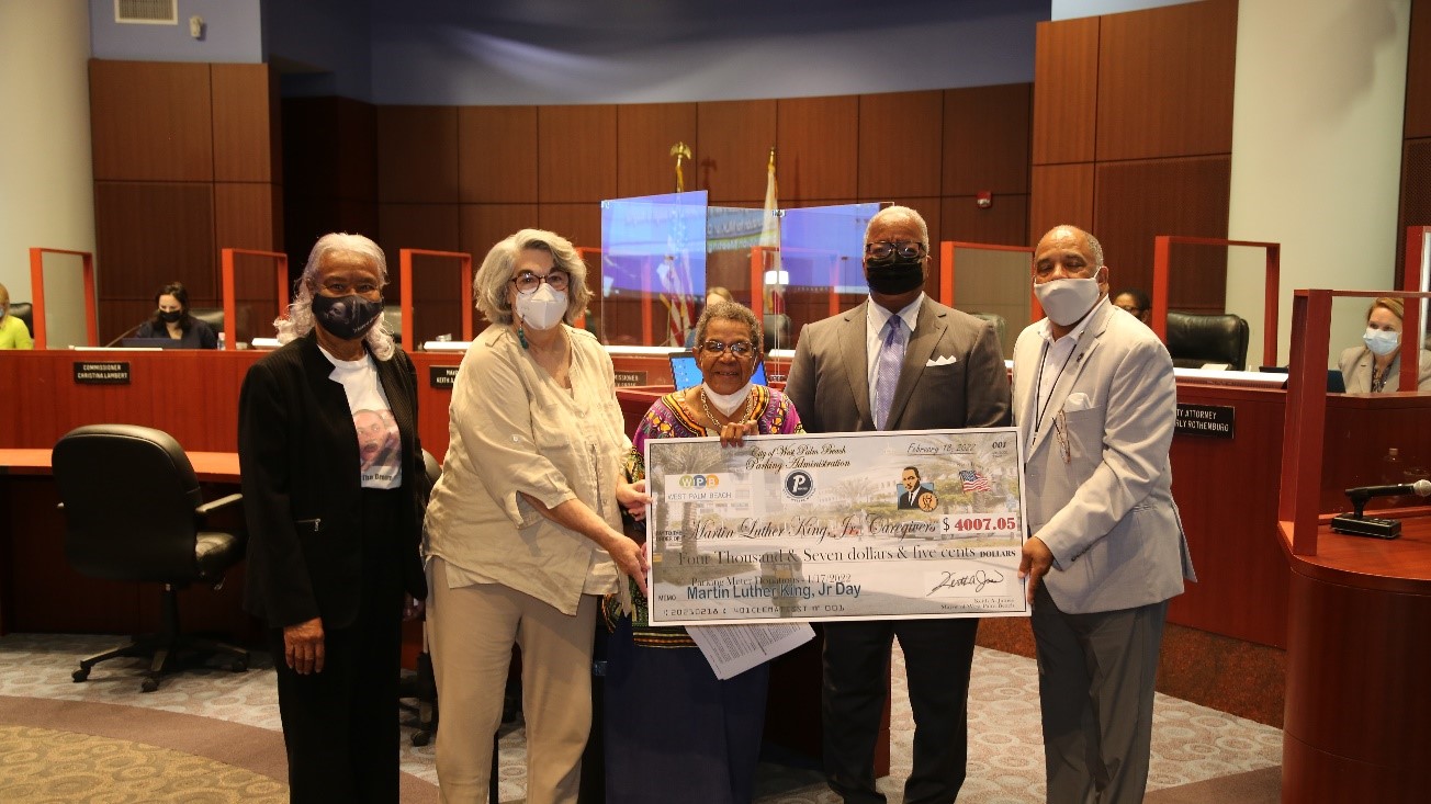 MLK Caregivers Program members accepting a ceremonial check from Mayor James