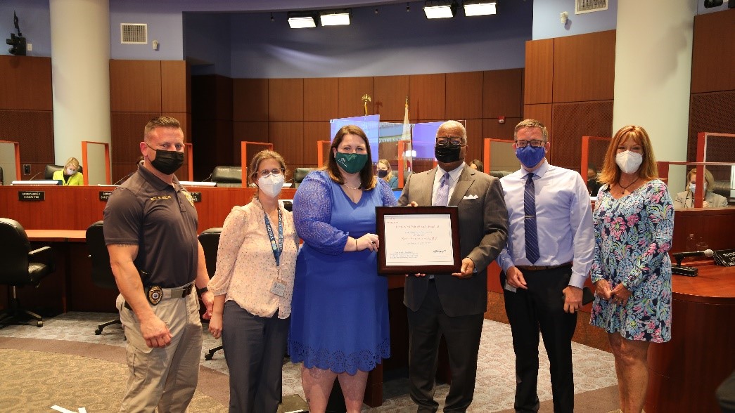 Keep America Beautiful Regional Director Mallory Coffey presents the city’s KAB certification to Mayor Keith A. James, who is joined by city employees